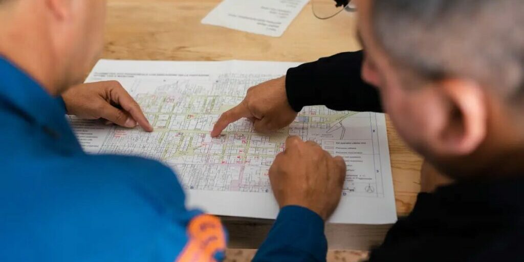image of two people engaged in collaborative construction over a blueprint drawing